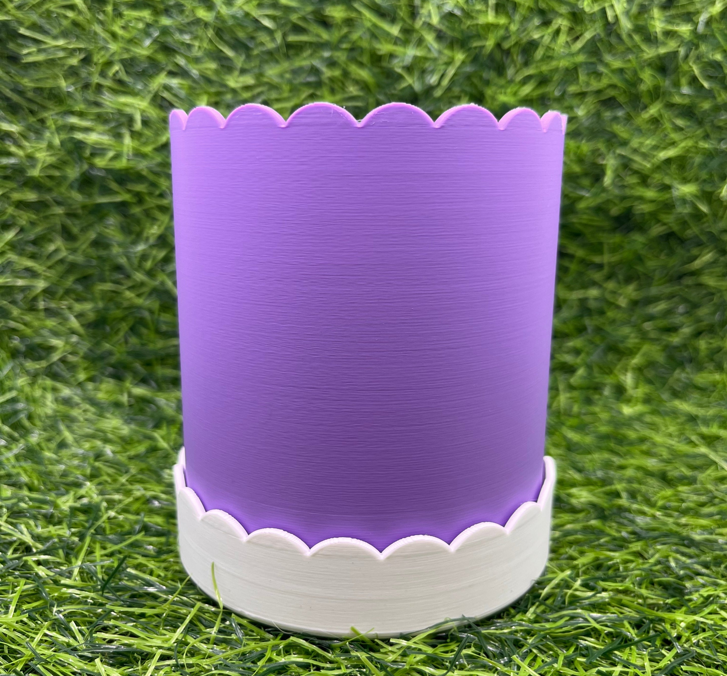 Purple and white plant pot on grass