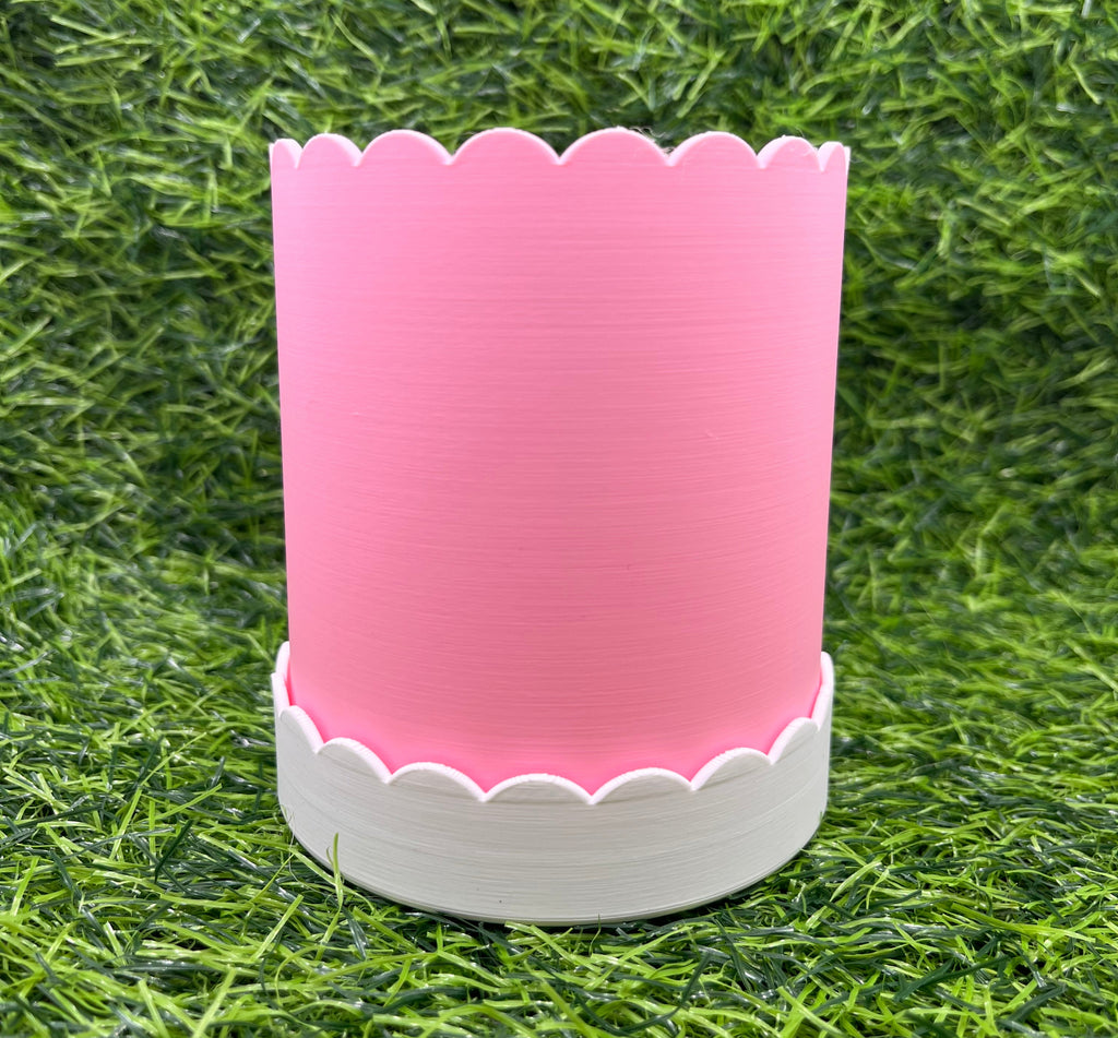 Pink and white plant pot on grass