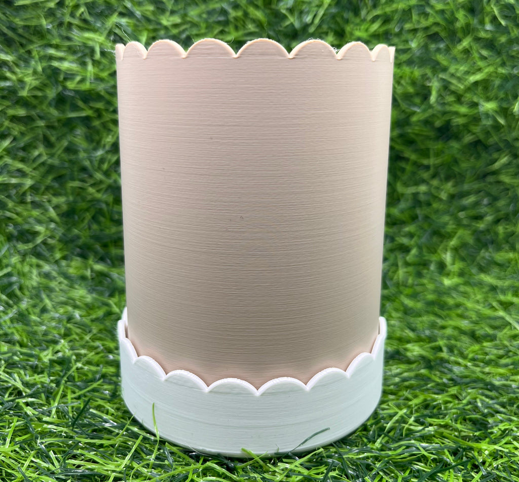 Beige scalloped-edged plant pot on grass